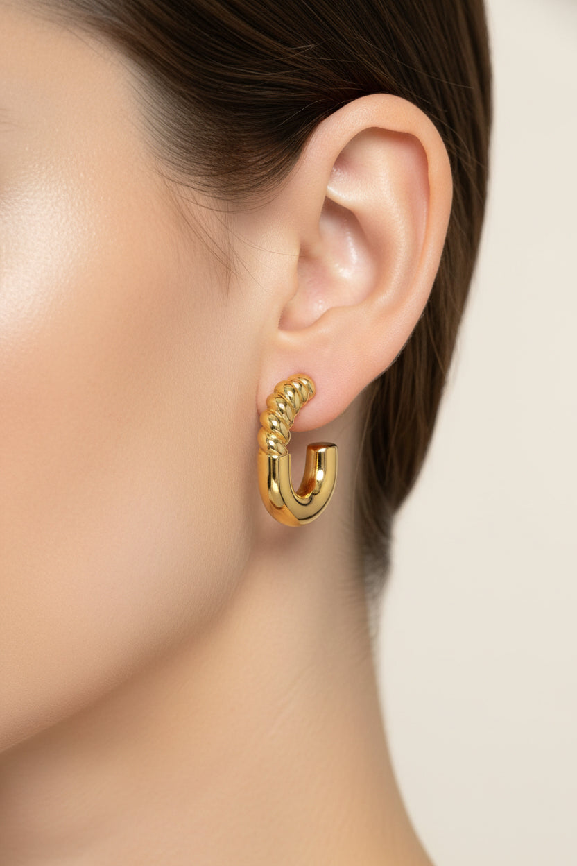 Gold plated twist curve hoop earrings worn on model, stainless steel 18K PVD gold with bold curved design