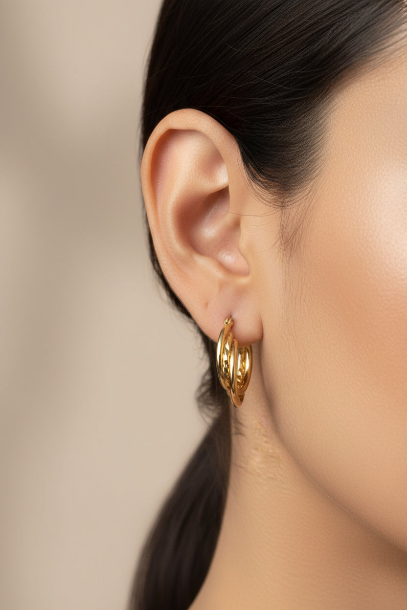Twist detail double hoop earrings in 18K PVD gold plated stainless steel worn on ear, polished double hoop design by GLISTIA