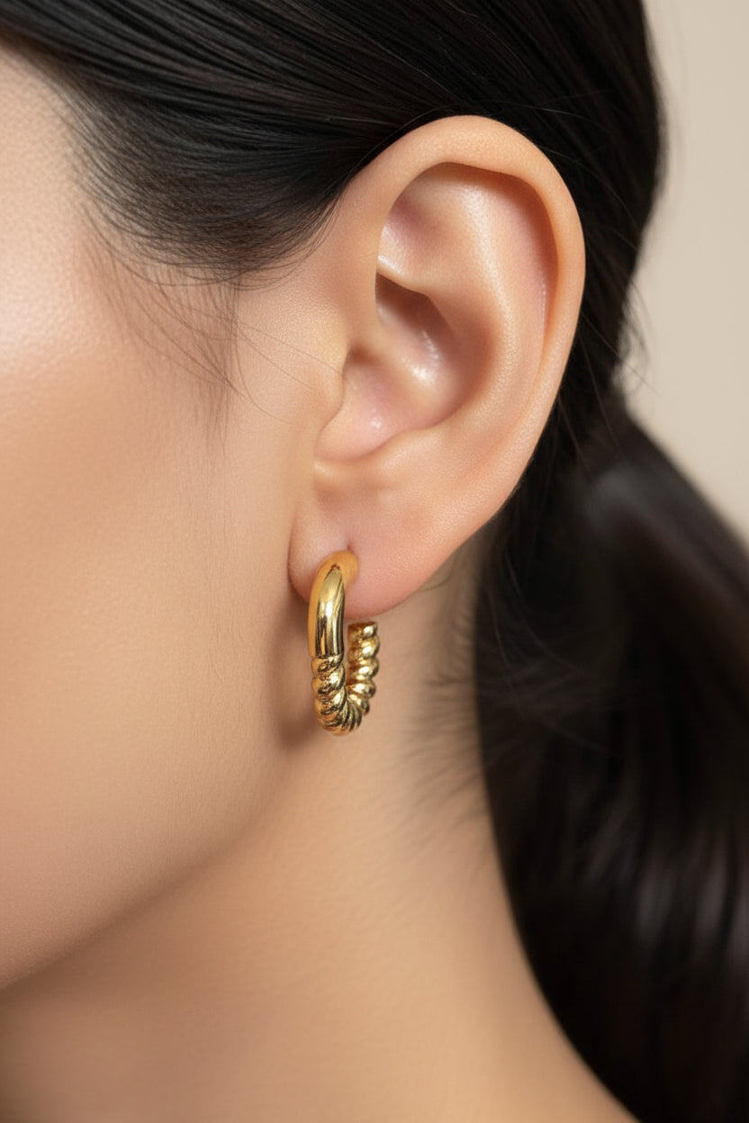 Twisted half hoop earrings crafted from stainless steel with 18K PVD gold plating, featuring a modern half hoop design and polished finish