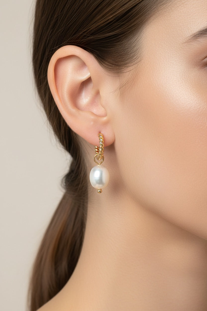 Twisted hoop pearl drop earrings crafted from stainless steel with 18K PVD gold plating, featuring a sculpted hoop and lustrous pearl drop