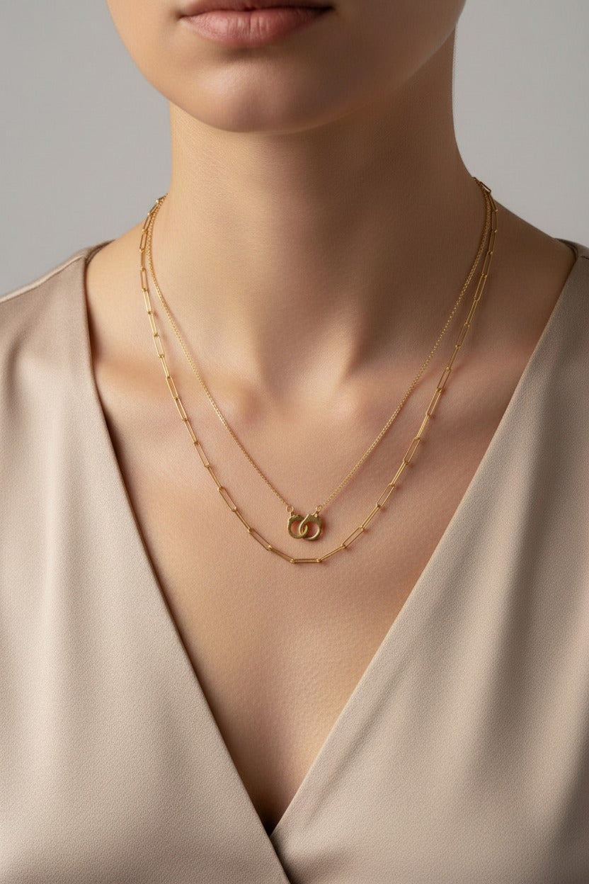 Unity Handcuff layered necklace crafted from stainless steel with 18K PVD gold plating, featuring interlinked handcuff design