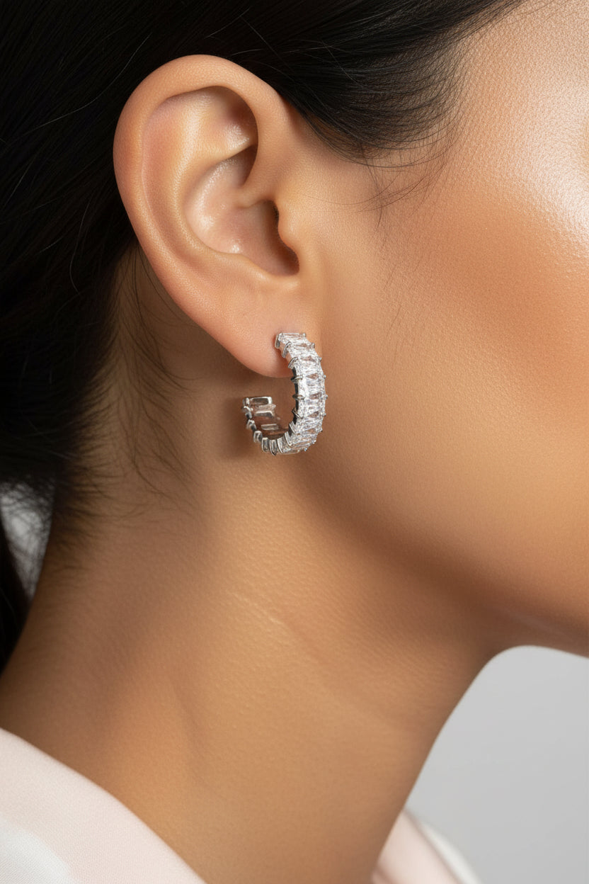 Close-up view of zirconia C-hoop earrings in polished stainless steel, featuring a modern half-hoop design with zirconia detailing